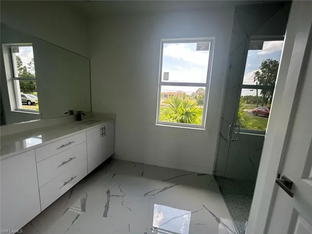 Bathroom with tile flooring, vanity, and a wealth of natural light