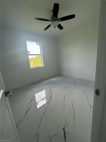 Tiled spare room with ceiling fan