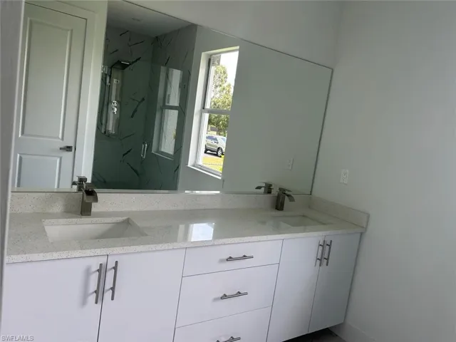 Bathroom with a tile shower and dual vanity