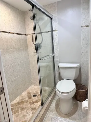 Bathroom featuring a shower stall and light tile patterned floors