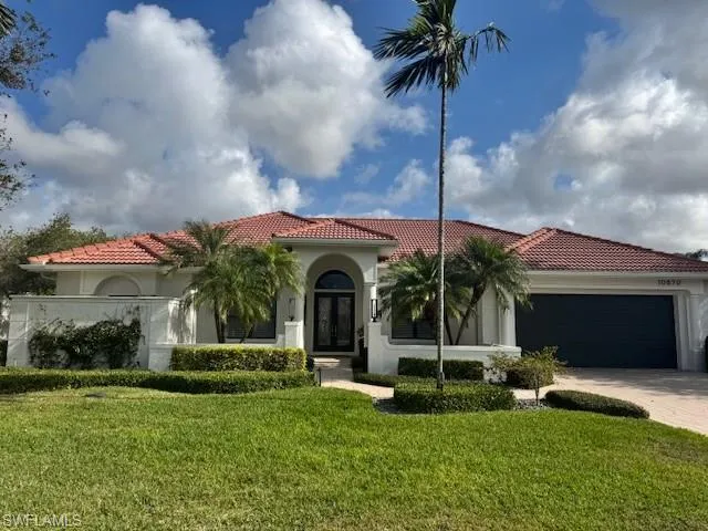 Mediterranean / spanish house with a garage and a front lawn