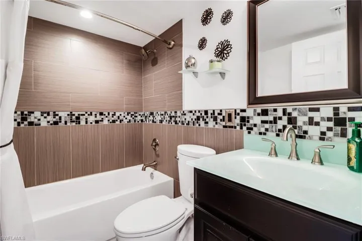 Full bathroom with vanity, toilet, and shower / bath combo with shower curtain