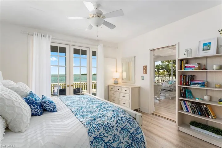 Bedroom featuring a water view, multiple windows, access to exterior, and french doors