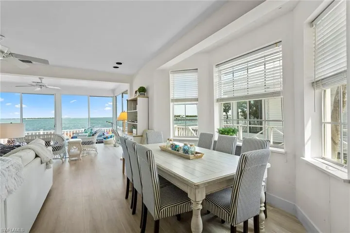 Dining area with a water view, light wood finished floors, and ceiling fan