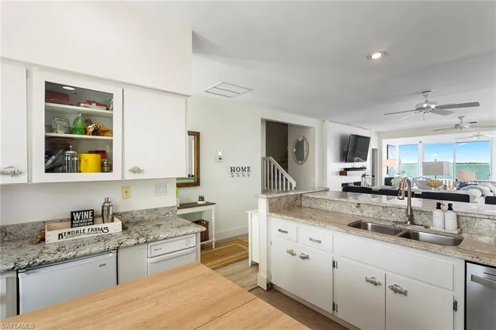 Kitchen with white cabinets, light stone countertops, white dishwasher, a ceiling fan, and recessed lighting