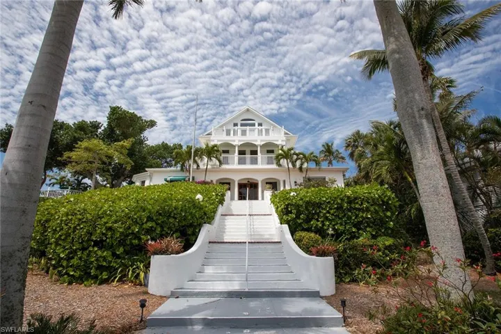 View of front of house with stairway and covered porch