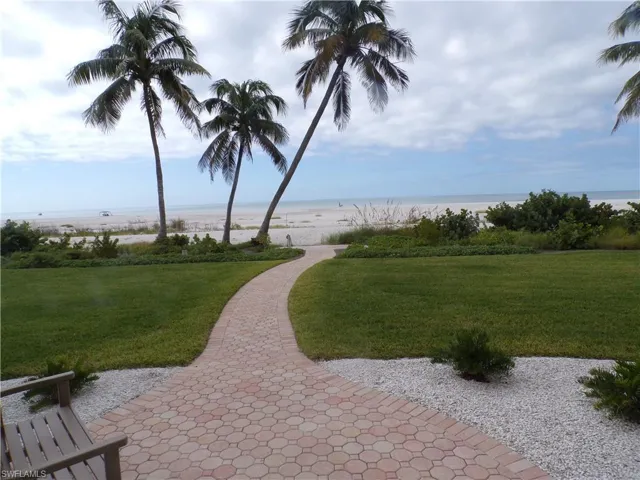 View of property's community with a water view and a lawn
