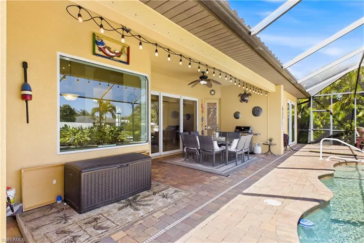 Expansive screened lanai offers the ultimate OUTDOOR ENTERTAINING experience with covered dining space, tropical ambiance & seamless access to the sparkling pool & spa area.