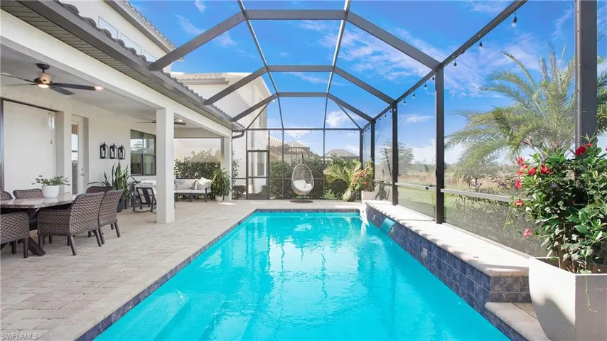 View of pool featuring ceiling fan, a lanai, an outdoor living space, pool water feature, and a patio