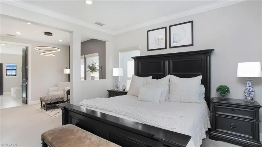 Carpeted bedroom featuring ensuite bathroom and crown molding