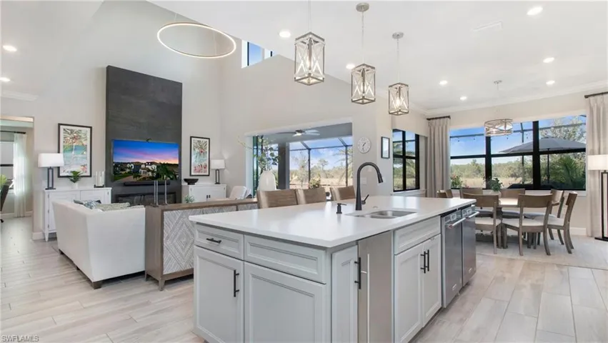 Kitchen with ceiling fan, a healthy amount of sunlight, sink, a center island with sink, and hanging light fixtures