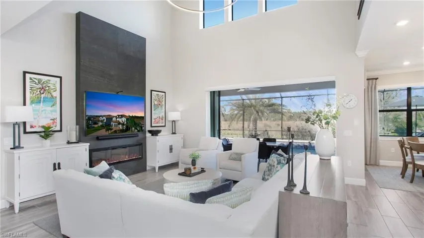 Living room featuring a fireplace, a high ceiling, and plenty of natural light