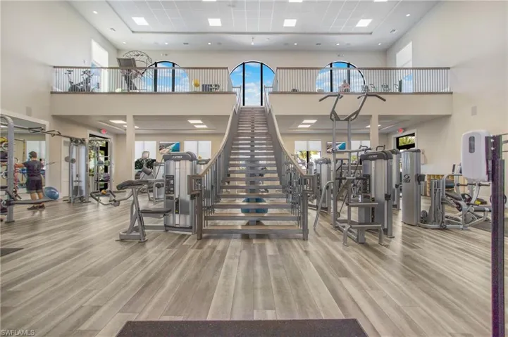 Workout area with wood-type flooring and a high ceiling