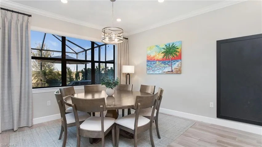 Dining space with a chandelier, light hardwood / wood-style flooring, and ornamental molding