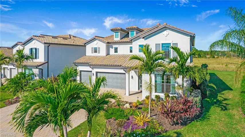 Mediterranean / spanish-style home with a front lawn and a garage