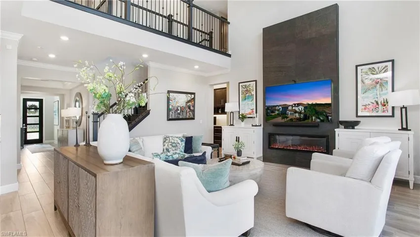 Living room with light hardwood / wood-style floors, crown molding, and a fireplace