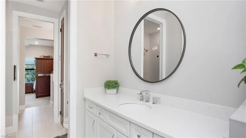 Bathroom featuring tile patterned floors, a shower, vanity, and toilet
