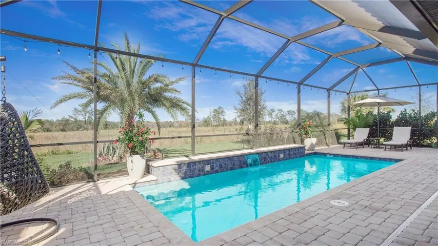 View of swimming pool with a patio and glass enclosure