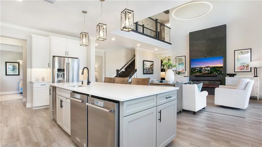 Kitchen featuring a kitchen island with sink, white cabinets, light hardwood / wood-style floors, and stainless steel refrigerator with ice dispenser