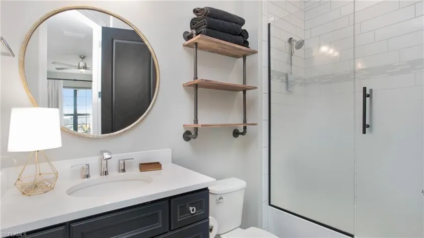 Bathroom featuring ceiling fan, vanity, and toilet