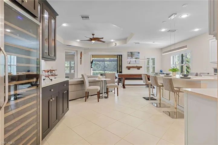 Kitchen featuring a tray ceiling, a wealth of natural light, ceiling fan, and pendant lighting