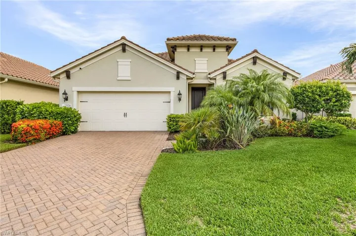 Mediterranean / spanish house with a garage and a front lawn
