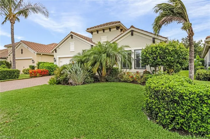 Mediterranean / spanish-style home with a garage and a front lawn
