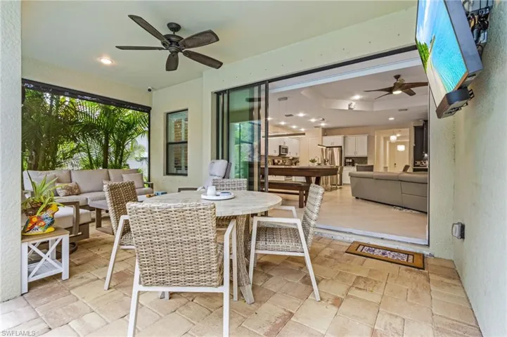 Sunroom / solarium featuring ceiling fan and a tray ceiling