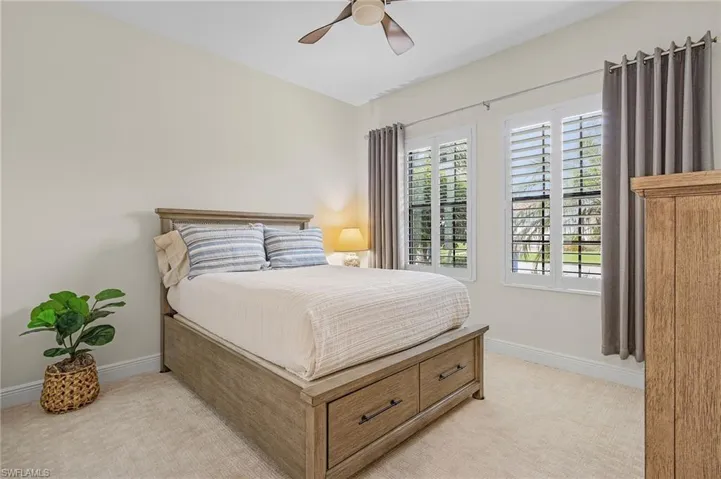 Carpeted bedroom featuring ceiling fan