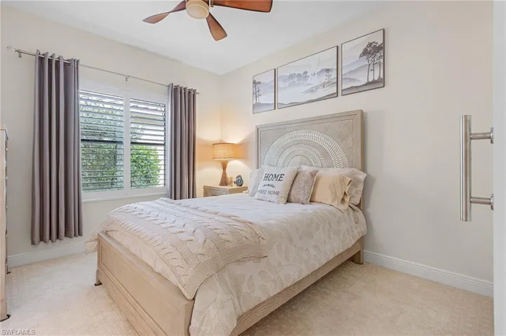 Bedroom featuring light colored carpet and ceiling fan