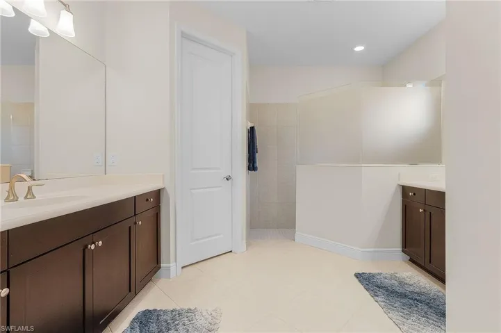 Bathroom featuring tile flooring, vanity, and tile walls