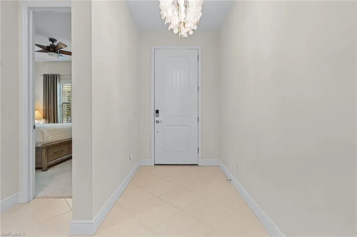 Entrance foyer featuring light colored carpet and ceiling fan with notable chandelier