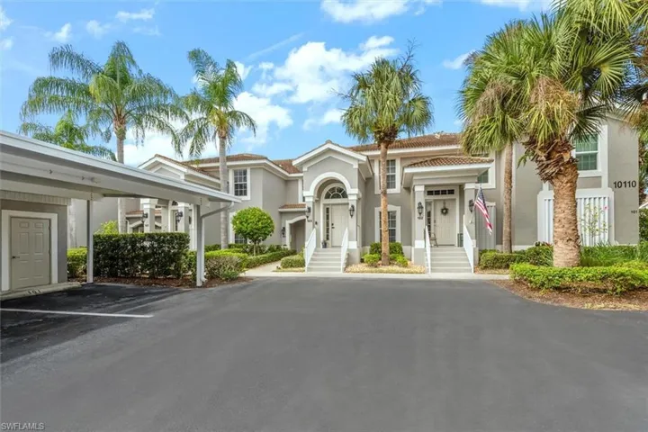 View of front of home featuring stucco siding and covered parking