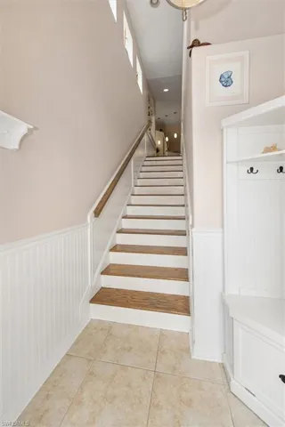 Staircase featuring tile patterned flooring, recessed lighting, and wainscoting