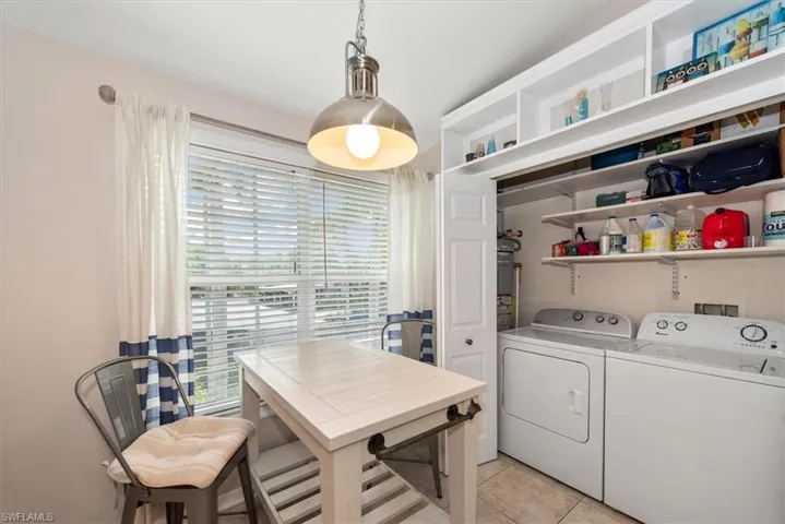 Washroom featuring light tile patterned flooring, washer and dryer, and an office area