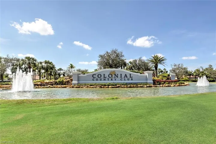 Community / neighborhood sign with a yard and a water view