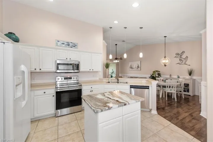 Kitchen featuring appliances with stainless steel finishes, pendant lighting, light tile patterned floors, white cabinetry, and recessed lighting