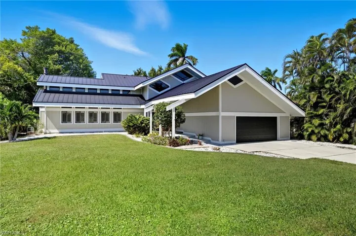 Contemporary exterior with a dark metal roof and light-toned siding