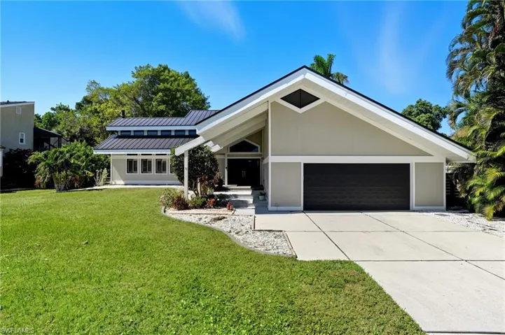 Contemporary exterior featuring a gabled roofline, metal roof, and an integrated two-car garage