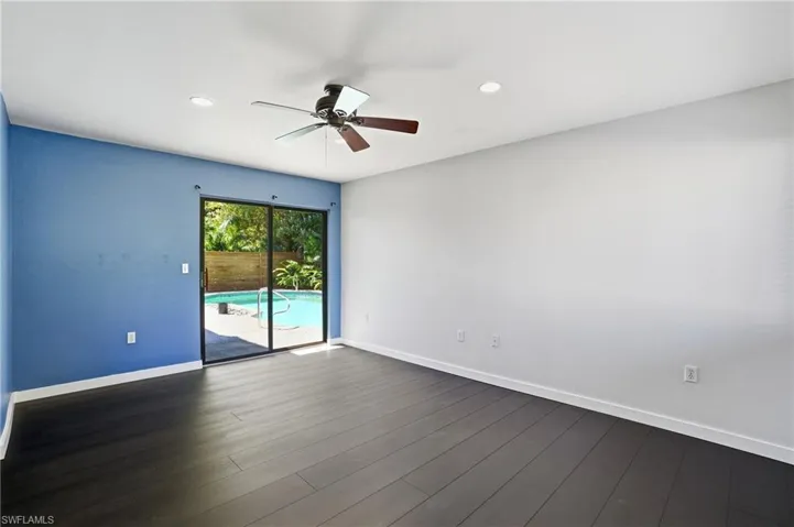 Interior space featuring dark wood-finish flooring and a blue accent wall