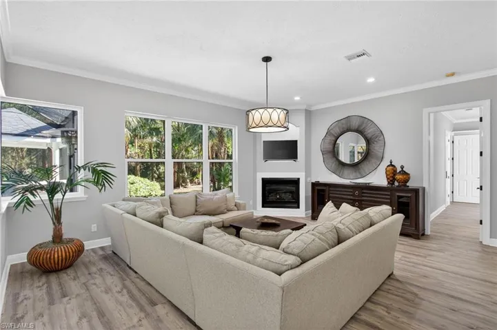 Great room off the kitchen  with fireplace and sliders out to the lanai via kitchen.