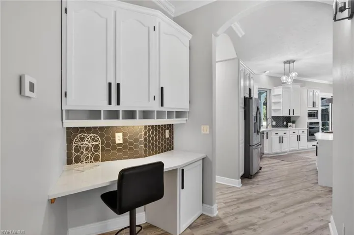 Desk with matching backsplash/cabinetry in an alcove off of the kitchen.