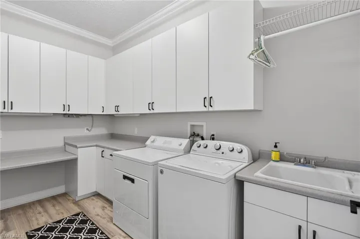 Spacious laundry with tons of storage, laundry sink, and folding area.