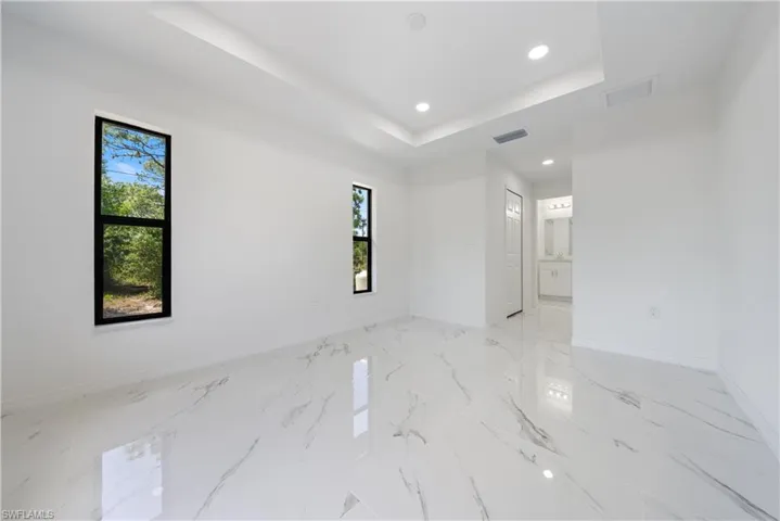 Unfurnished room featuring visible vents, baseboards, and a wealth of natural light