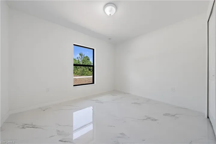 Spare room with marble finish floor and baseboards