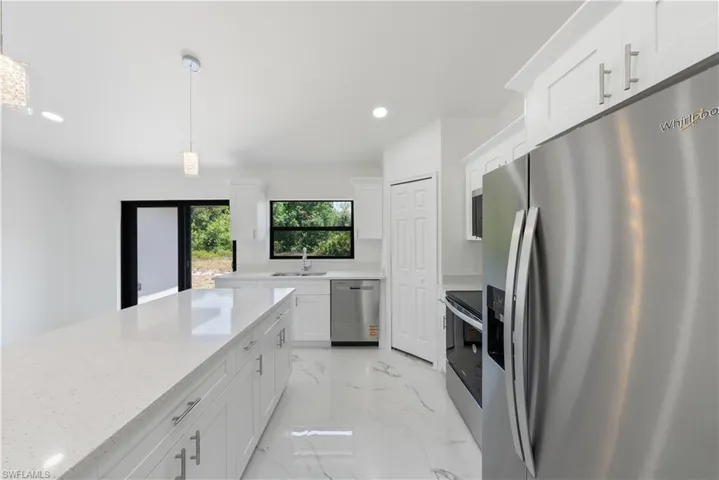 Kitchen featuring stainless steel appliances, recessed lighting, white cabinetry, and a sink