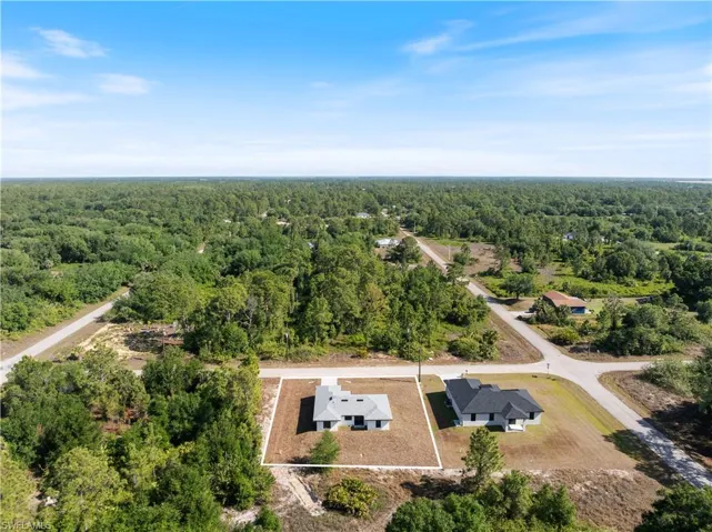 Birds eye view of property with a view of trees