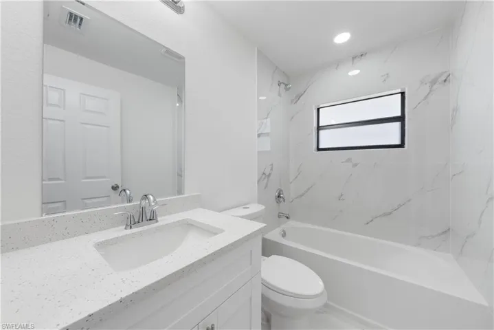 Full bathroom with vanity, visible vents, bathtub / shower combination, and toilet