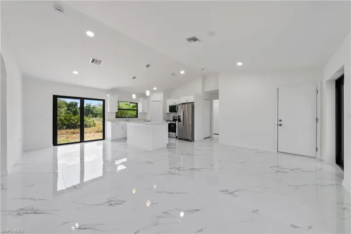 Unfurnished living room with recessed lighting, visible vents, and lofted ceiling