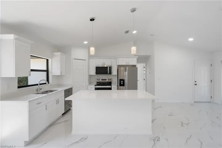 Kitchen featuring visible vents, white cabinets, a sink, appliances with stainless steel finishes, and a kitchen island